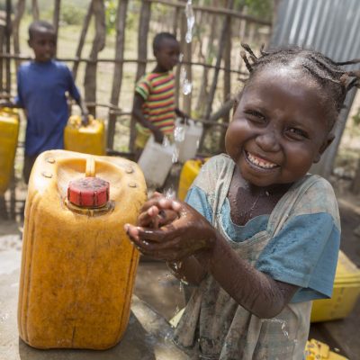 Meseret washes her hands with clean water at the Ropi-Sinta borehole installed by ChildFund in Siraro District, Ethiopia.