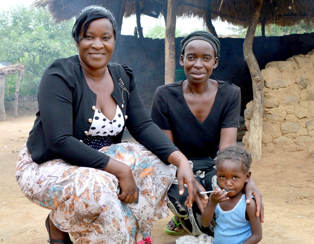 Two-year-old girl with her mother and neighbour in Zambia